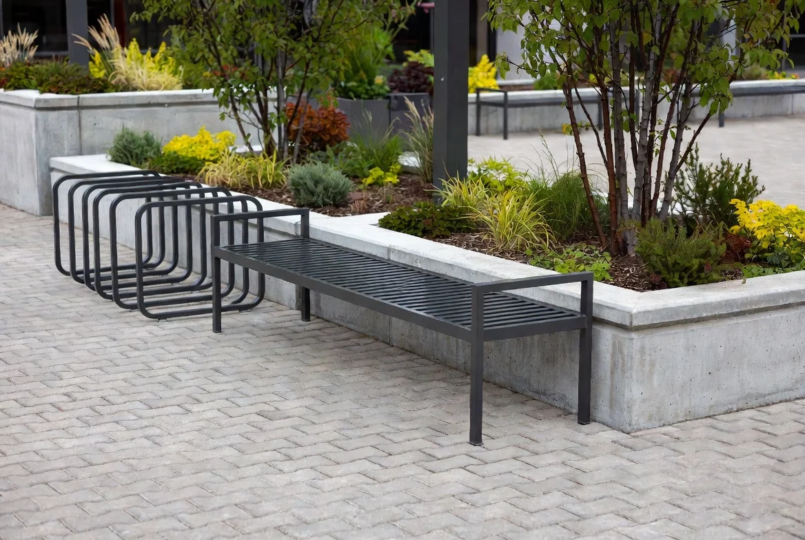 Commercial site furniture in Edmonton — bench, bike racks, and raised concrete planters on paving stone