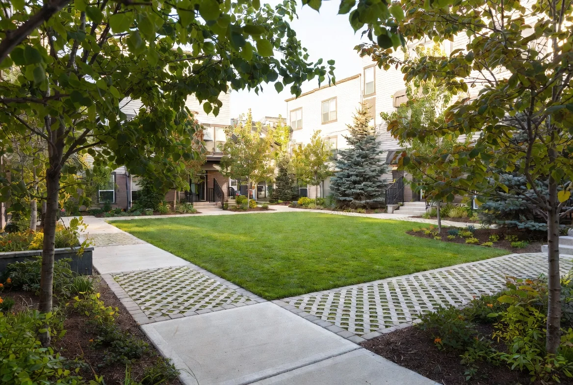 Multi-family courtyard landscaping in Edmonton with sod, permeable paving, and mature trees