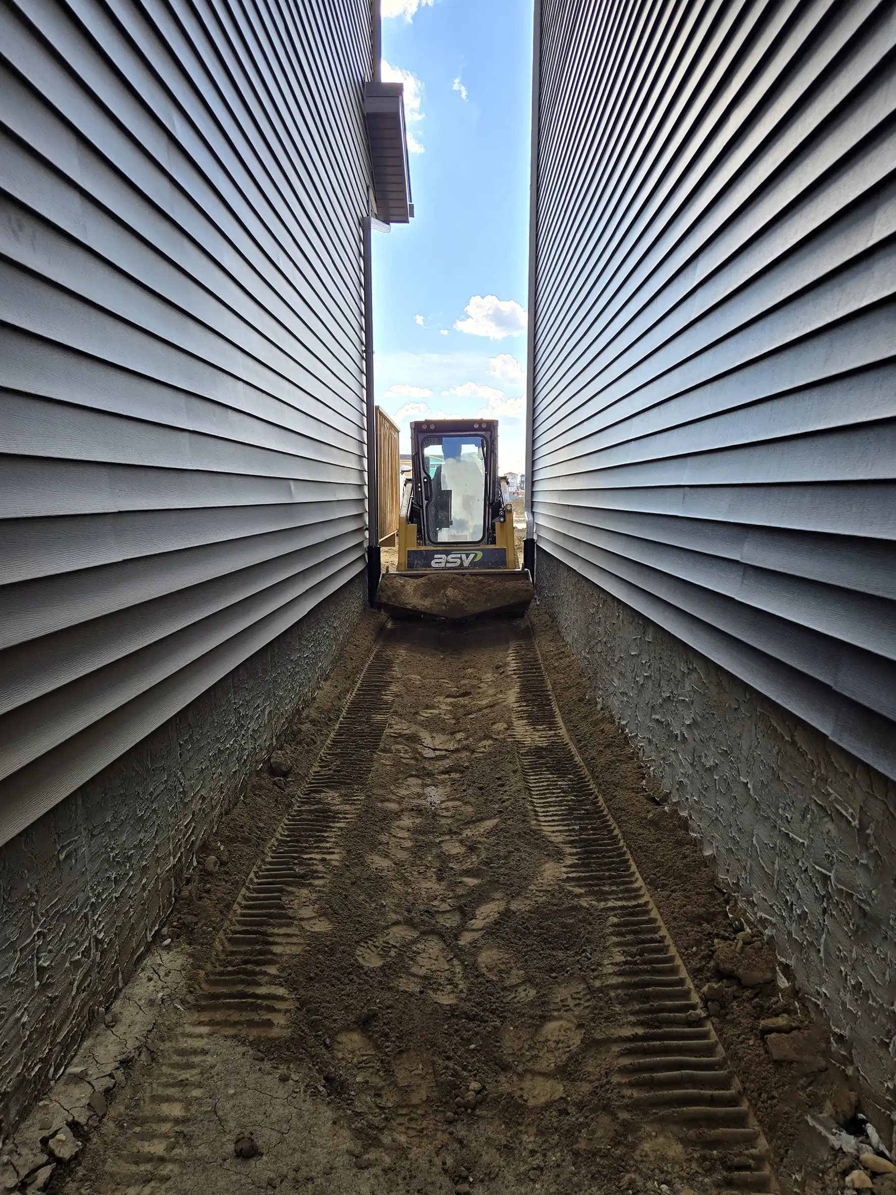 Rough grading zero lot line production homes in Edmonton
