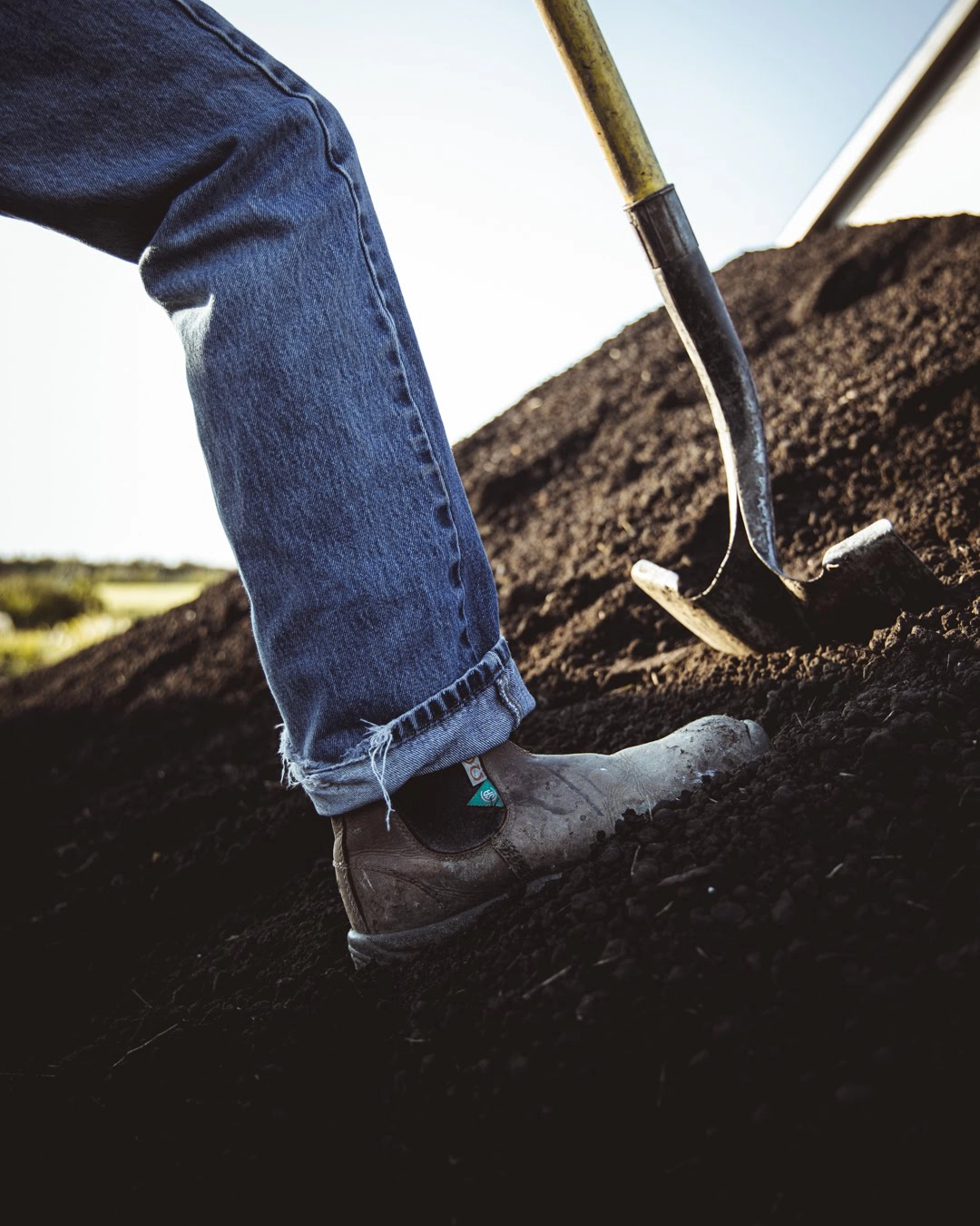 Landscaper working topsoil during final grading in Edmonton
